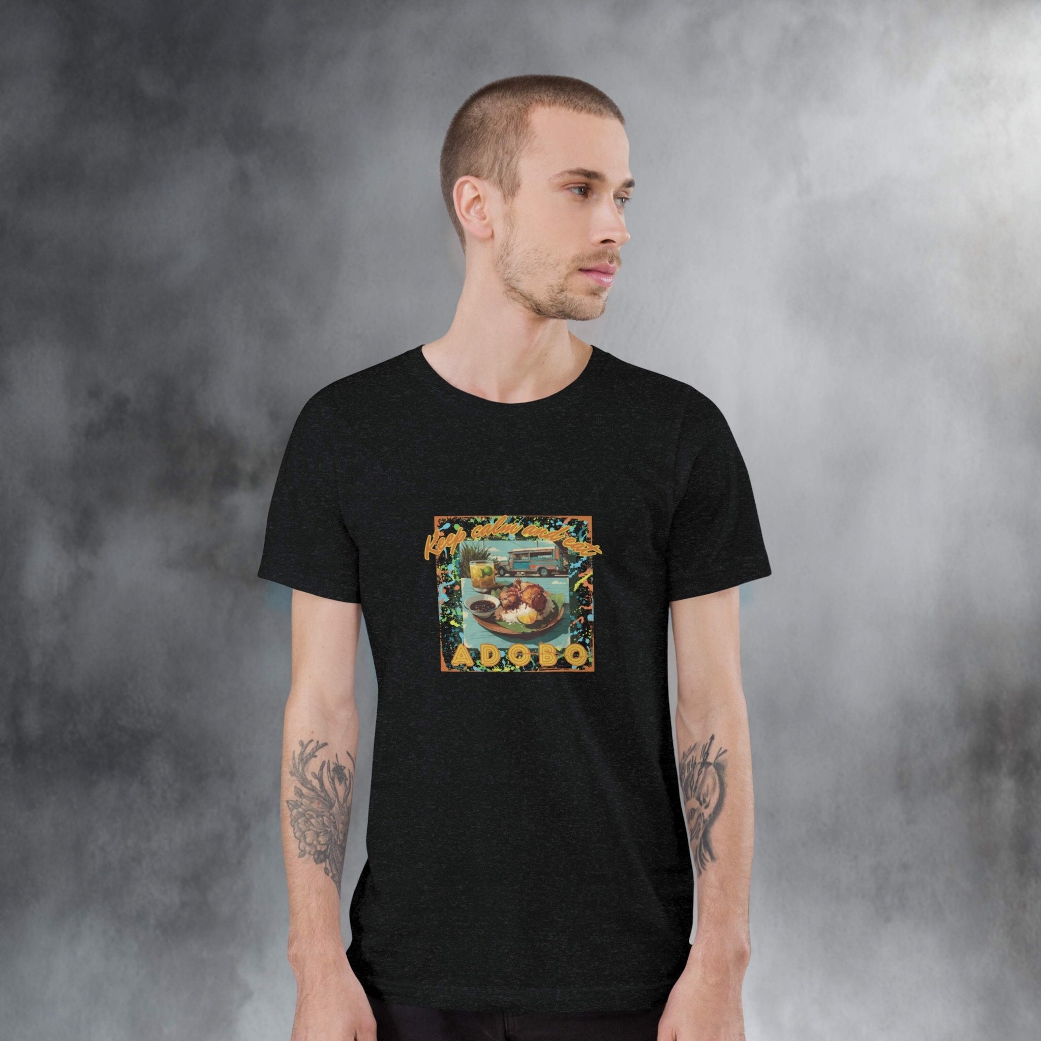 Man wearing a black t-shirt with a colorful graphic design of Adobo against a gray background