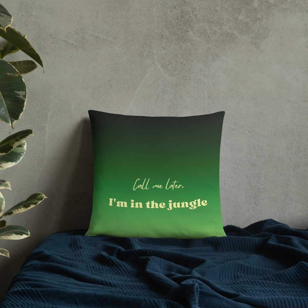 Green pillow with text 'Call me later, I'm in the jungle' on a textured wall background