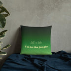 Green pillow with text 'Call me later, I'm in the jungle' on a textured wall background