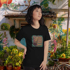 Woman wearing a black t-shirt with a colorful graphic designof a monkey at batu caves  in front of a vibrant, outdoor background.