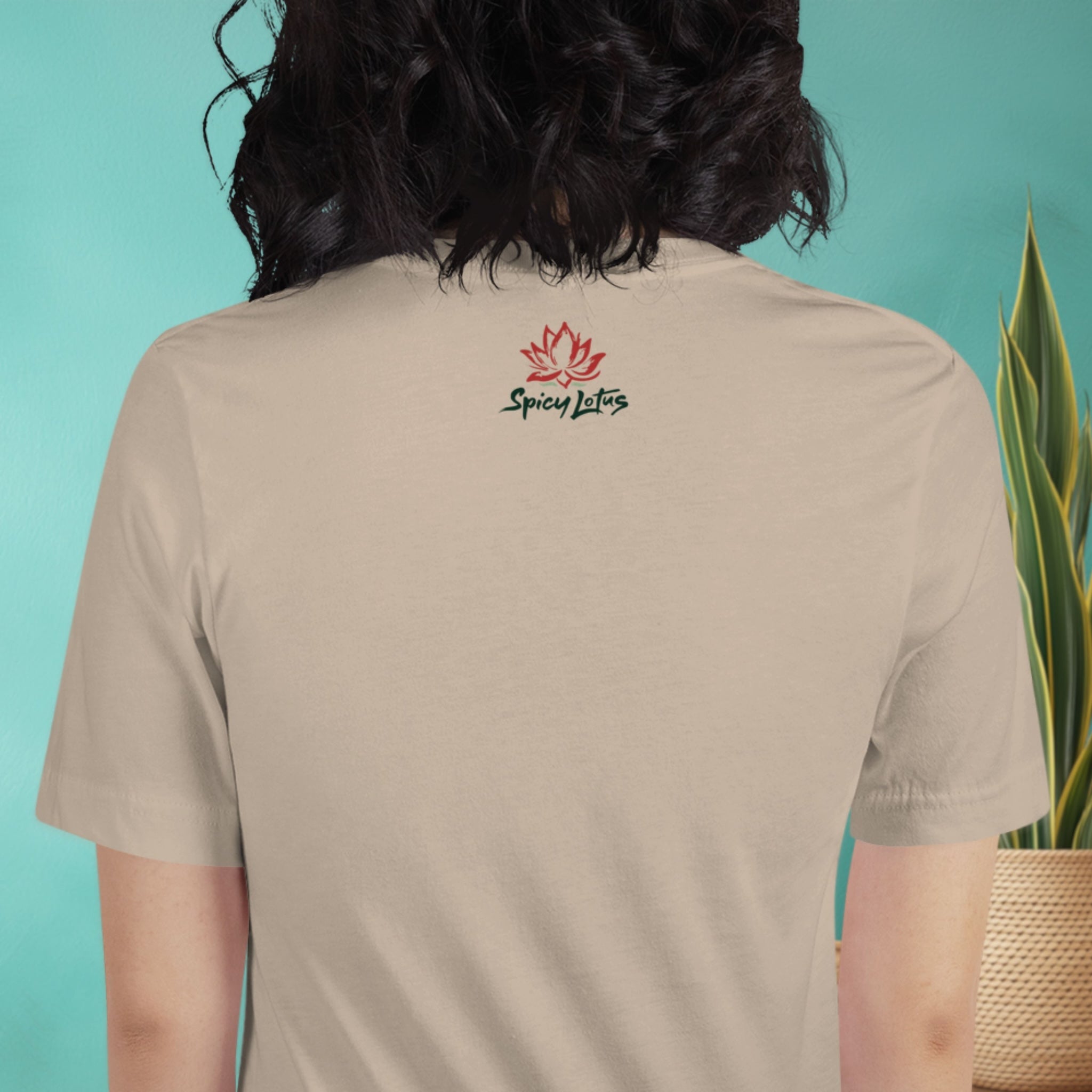 Woman wearing a beige t-shirt with 'Spicy Lotus' logo on the back, against a teal background.