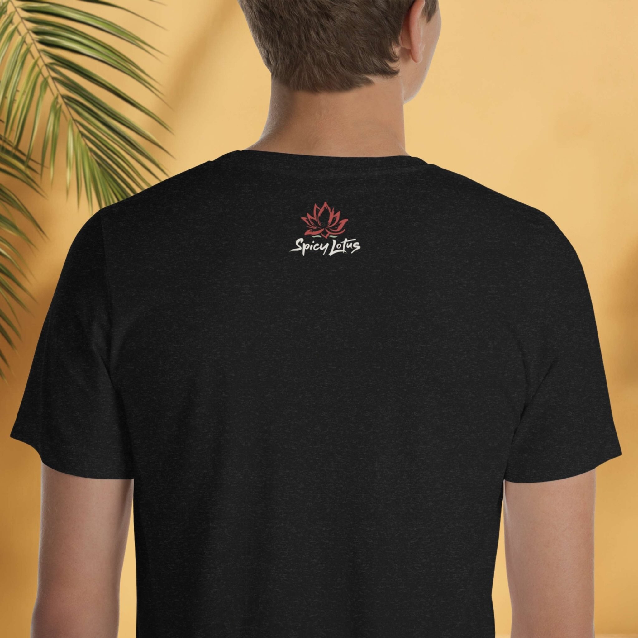 Person wearing a black t-shirt with a logo and tbrand name on the back, against a yellow background with a palm leaf.