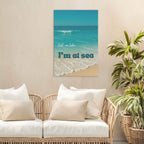 Beach-themed wall art above a wicker sofa with white cushions.