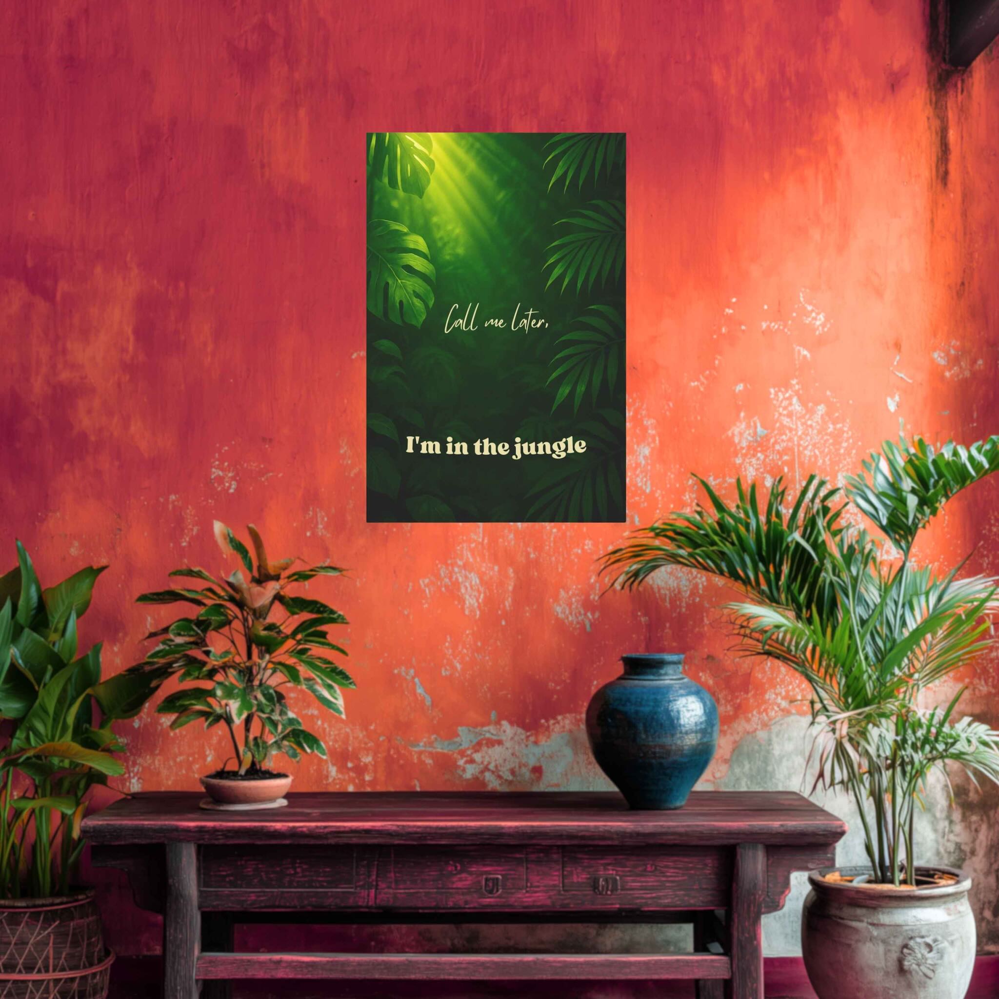 Decorative wall art with tropical leaves and text on a textured red wall with plants and a table.