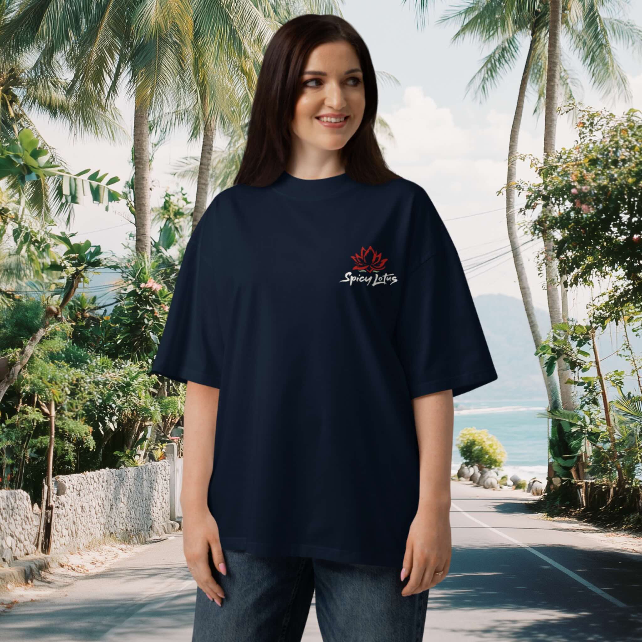 Woman wearing a navy blue organic tee with a Spicy Lotus chest logo in a tropical setting