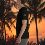 Person wearing a black t-shirt with a logo against a sunset palm tree background