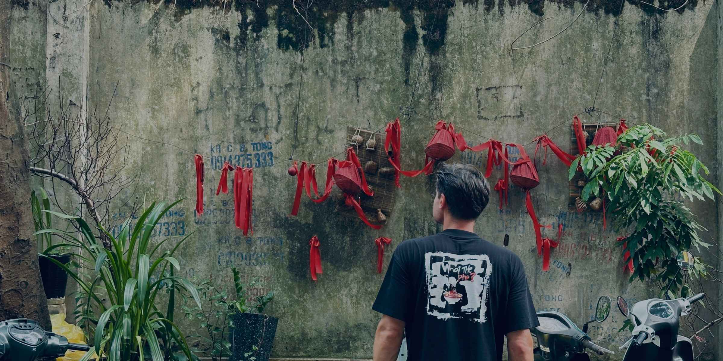 Person standing in a Vietnamese street wearing a Spicy Lotus shirt with graphic design.