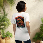 Wall Whisperers Midnight in Siam gecko back print white t-shirt on a woman standing in front of wall with tropical plants on both sides