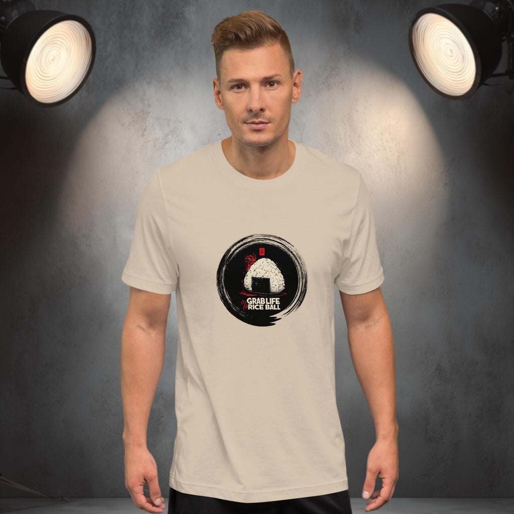 Man wearing a beige t-shirt with a graphic design of japanese onigiri 'grab life by the rice ball' on a gray background