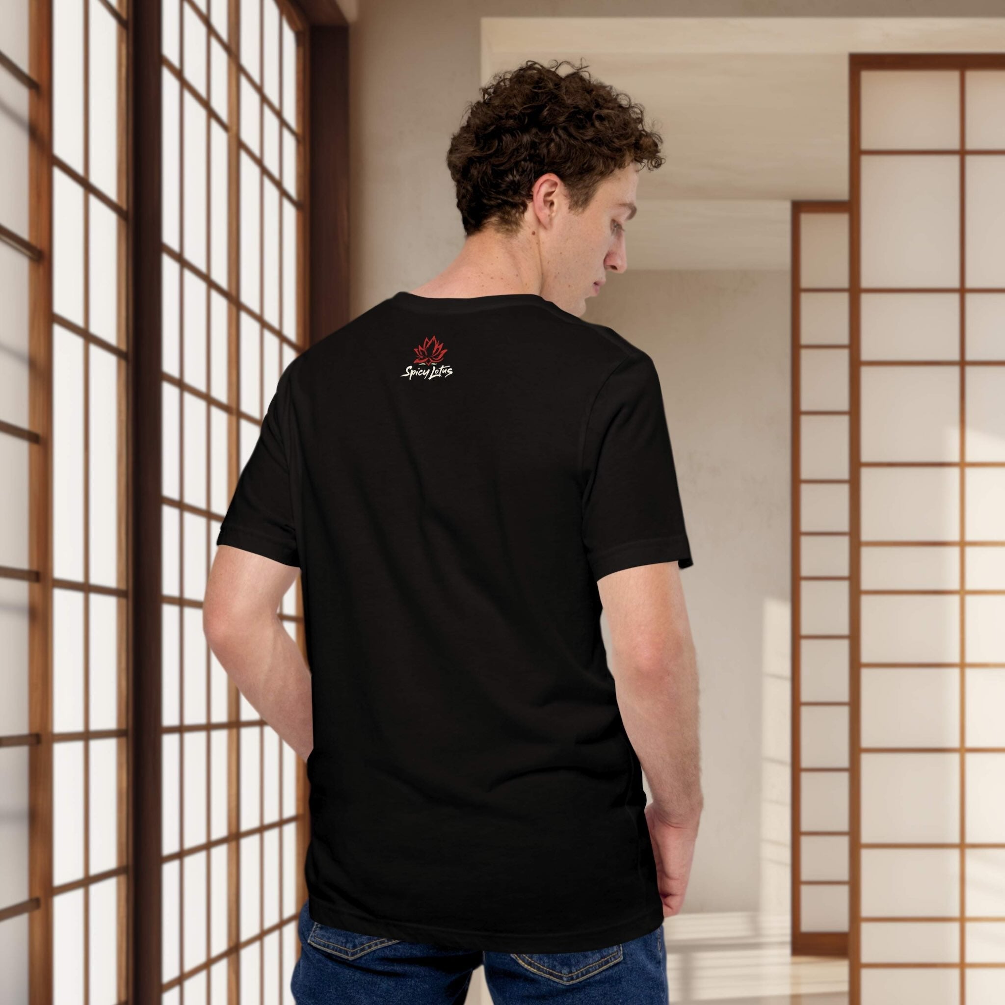 Person wearing a black t-shirt with a logo, standing in a room with wooden sliding doors.