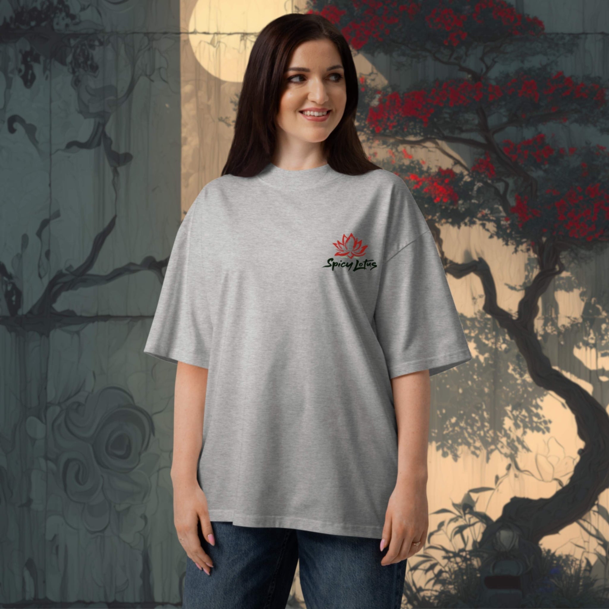 Woman wearing a gray t-shirt with a logo in front of a decorative wall.