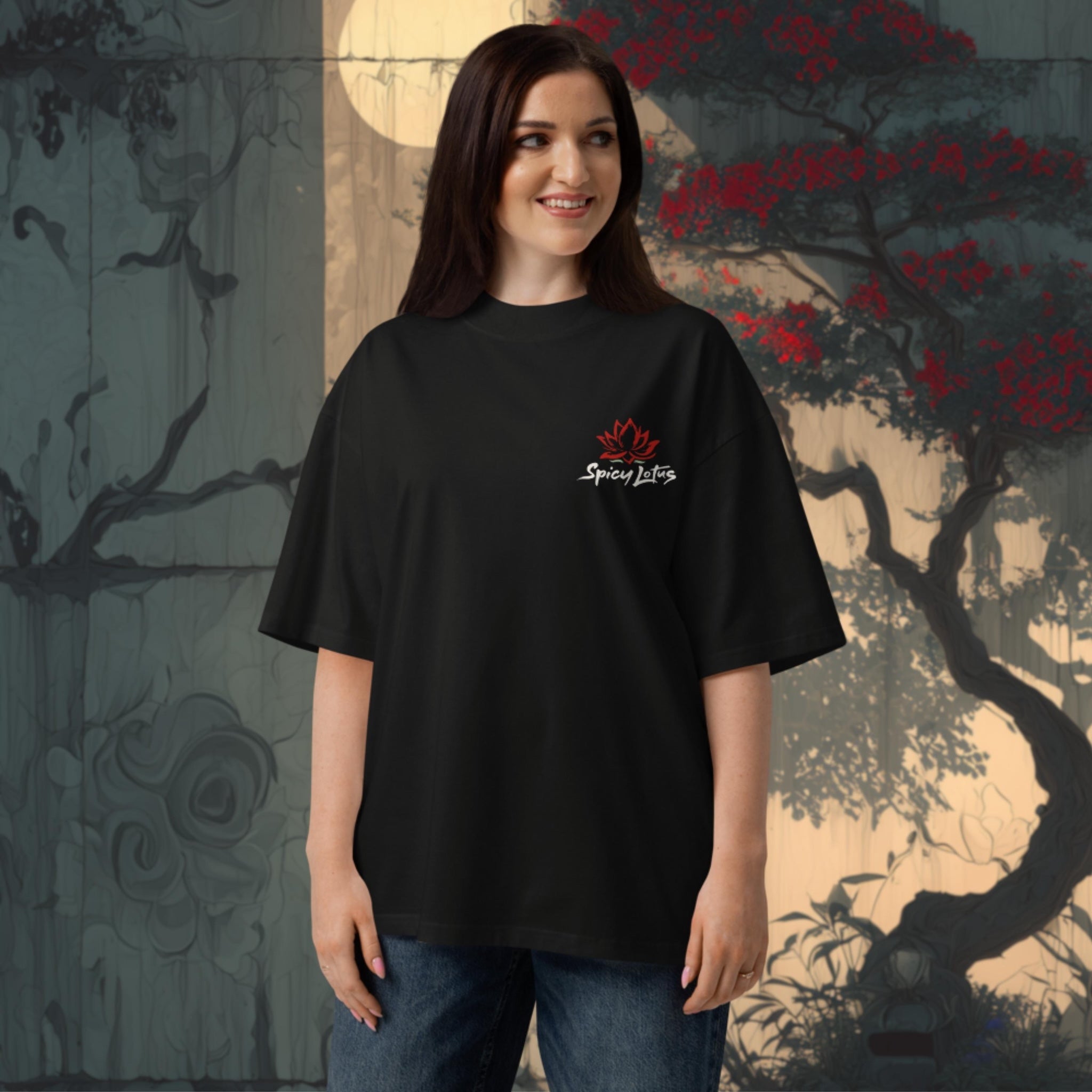Woman wearing a 100 % organic cotton black t-shirt with a logo in front of a decorative wall.