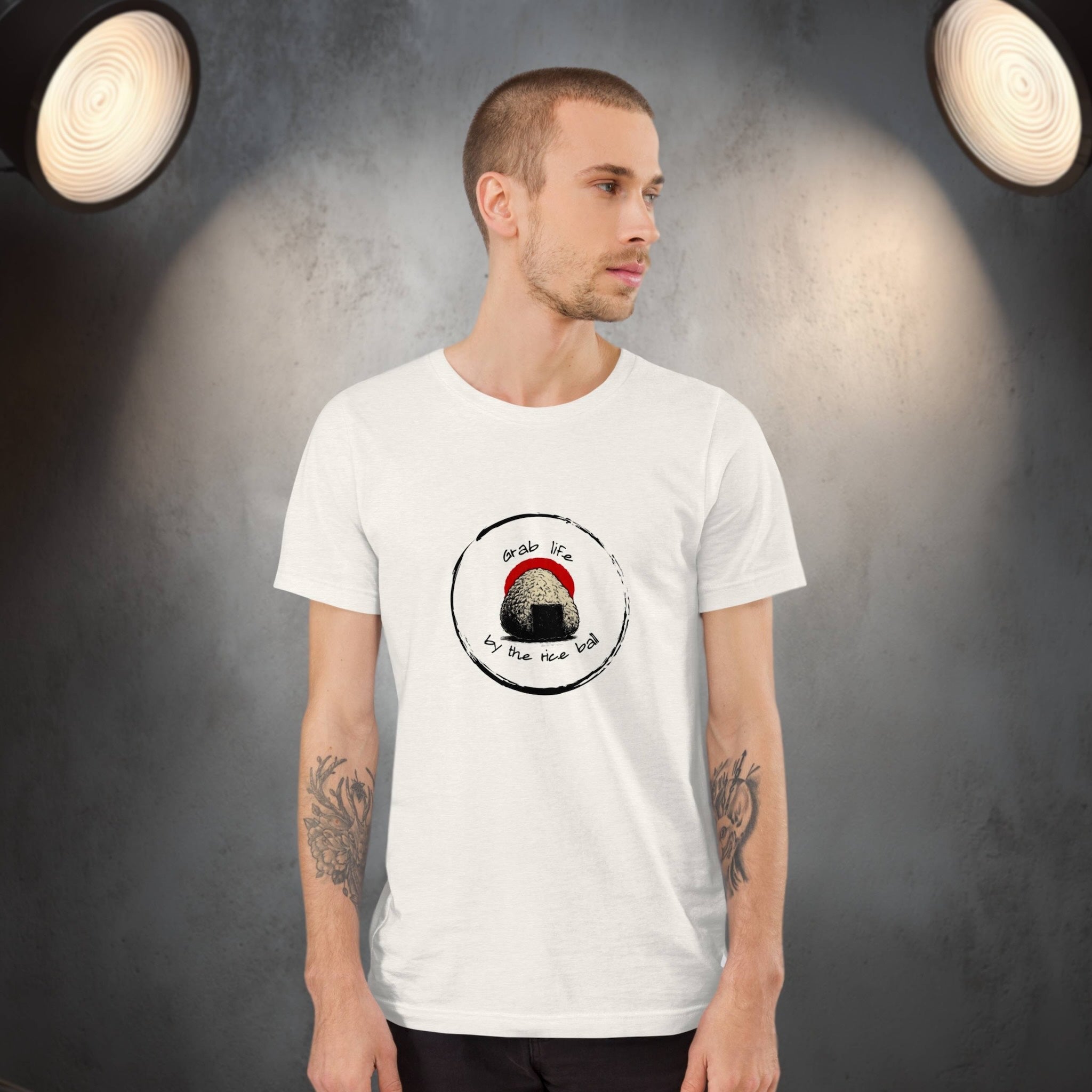 Man wearing a white t-shirt with a graphic design of onigiri rice ball with pun on a dark background