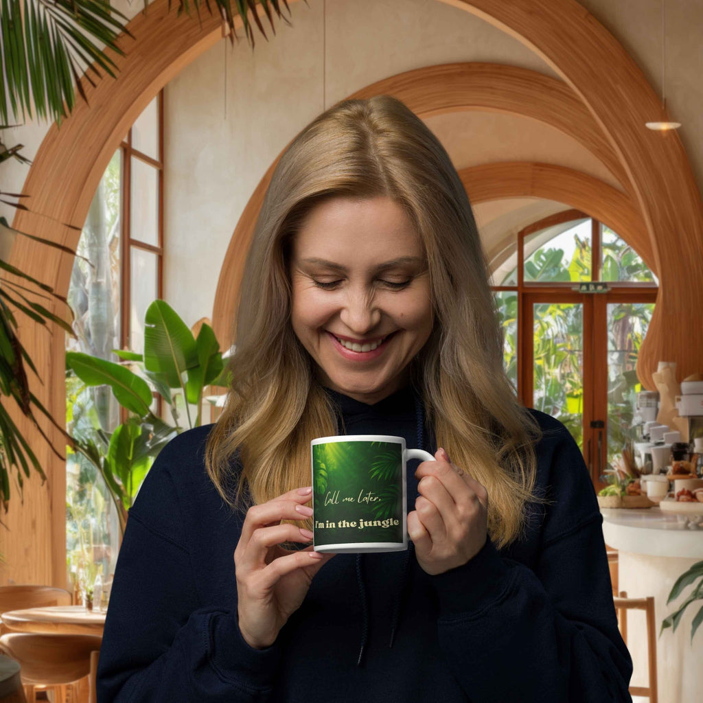 Woman holding a mug with a green design in a cozy indoor setting