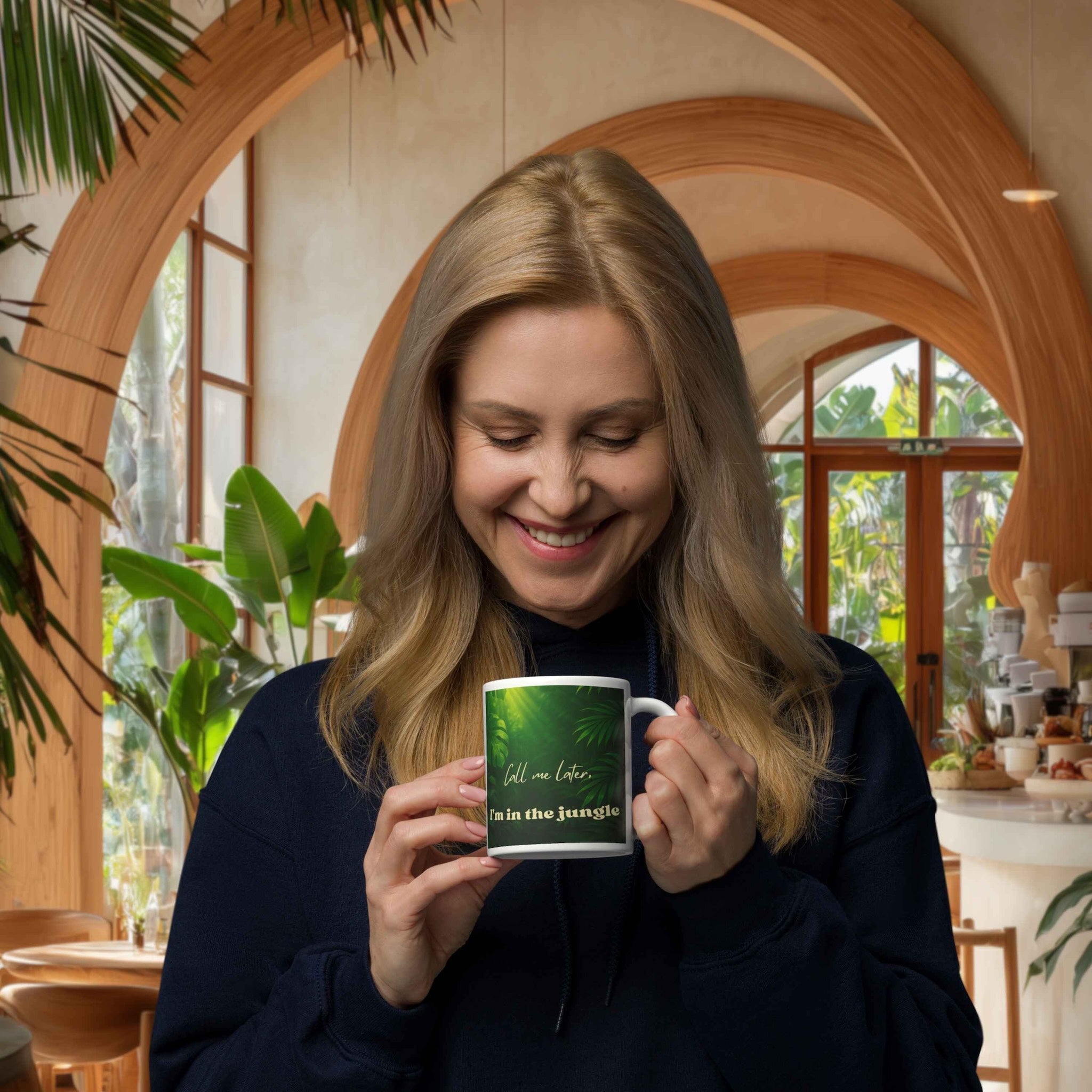 Woman holding a mug with a green design in a cozy indoor setting