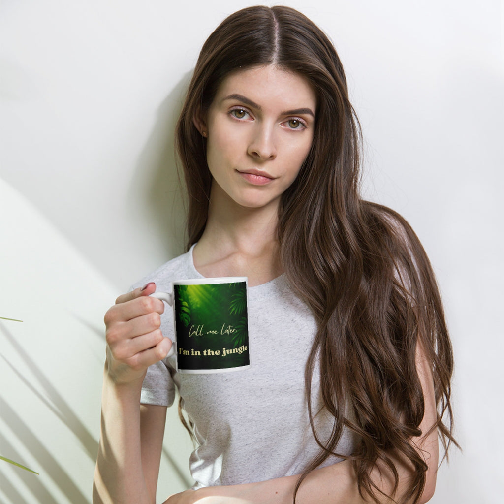 Woman holding a jungle design mug with a green design and text against a white background
