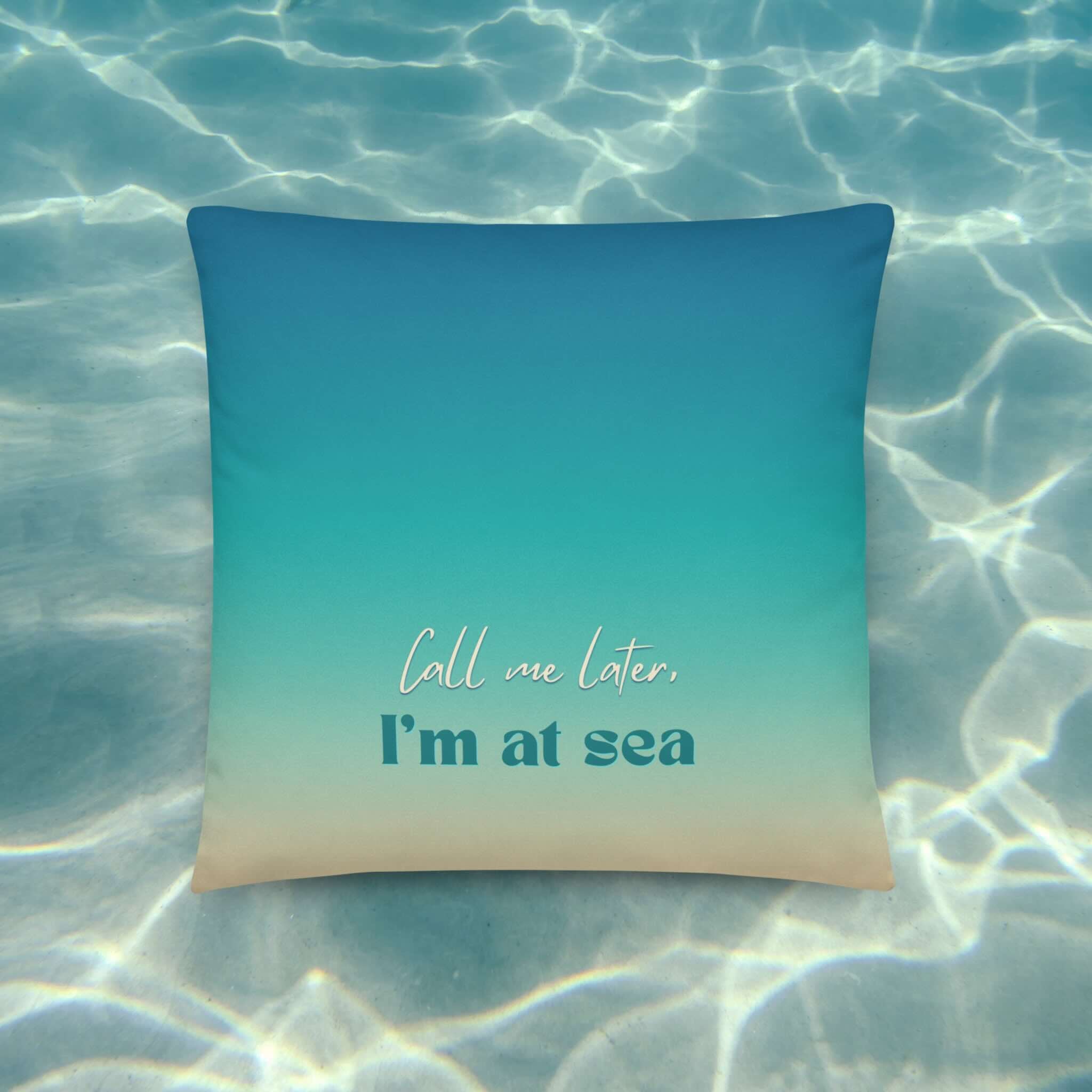 Blue pillow with 'Call me later, I'm at sea' text on a water background