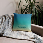 Blue pillow with text on a couch next to a plant