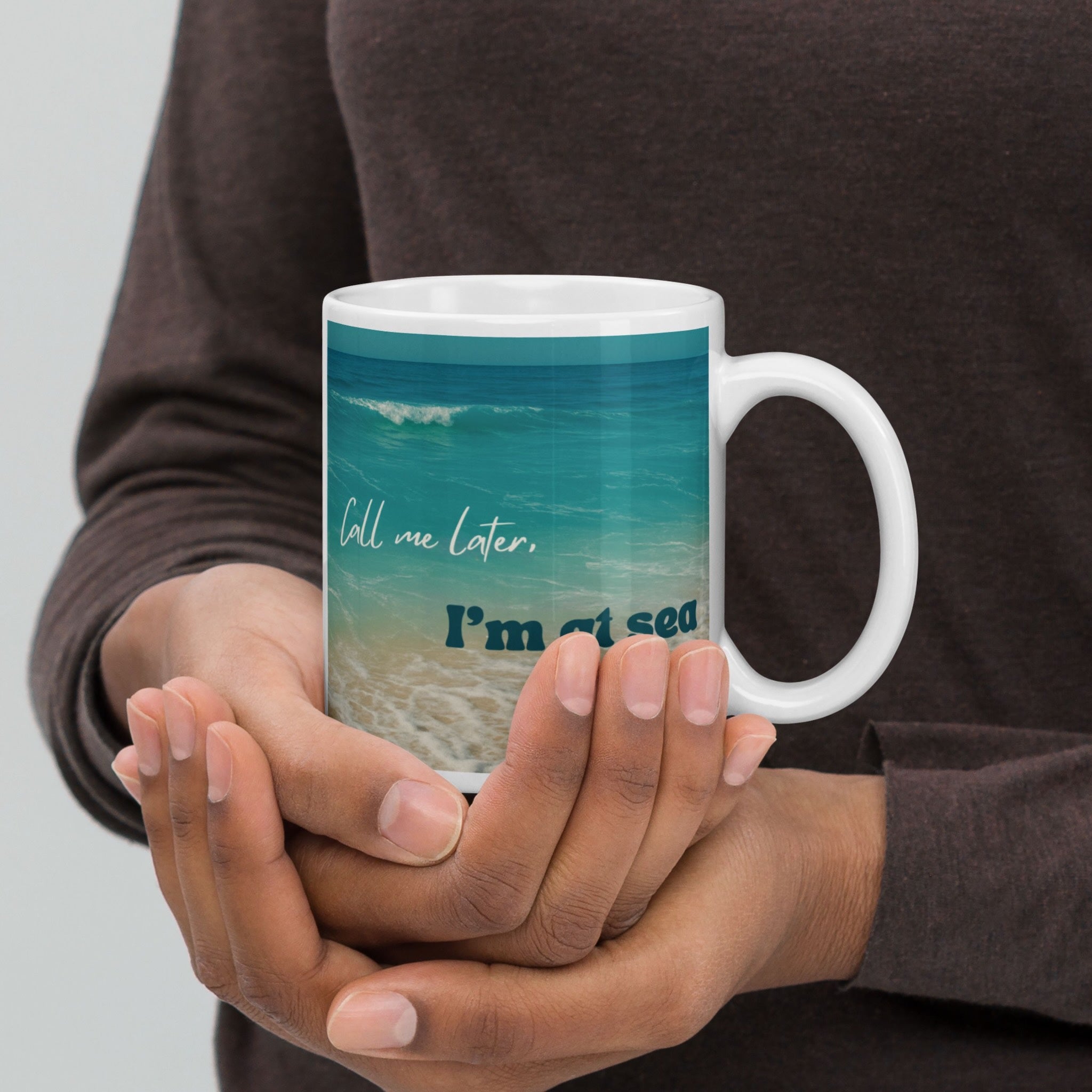 Person holding a mug with a scenic design and text.