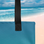 Close-up of a blue bag with a black strap against a beach background