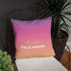 Gradient pillow with 'Call me later, I'm at sunset' text on a chair with a plant in the background