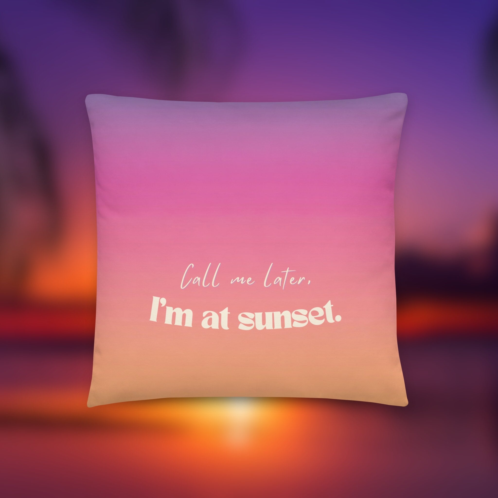 Pillow with 'Call me later, I'm at sunset' text on a blurred sunset background