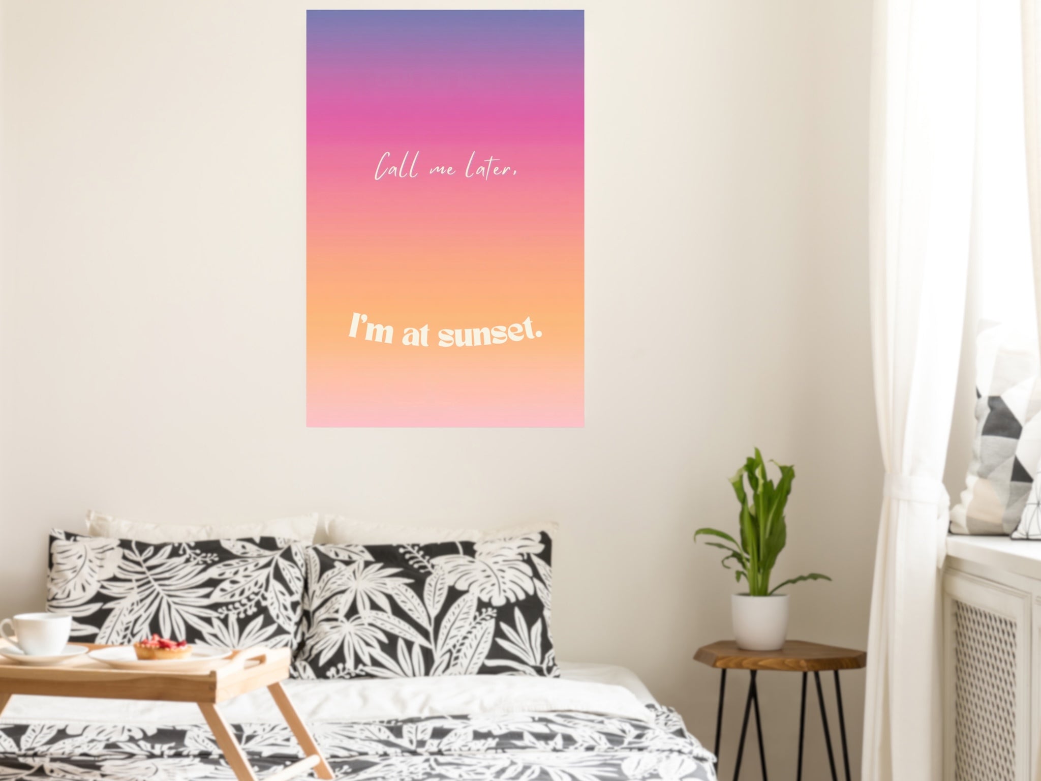 Poster with 'Call me later, I'm at sunset' text on a wall above a bed.