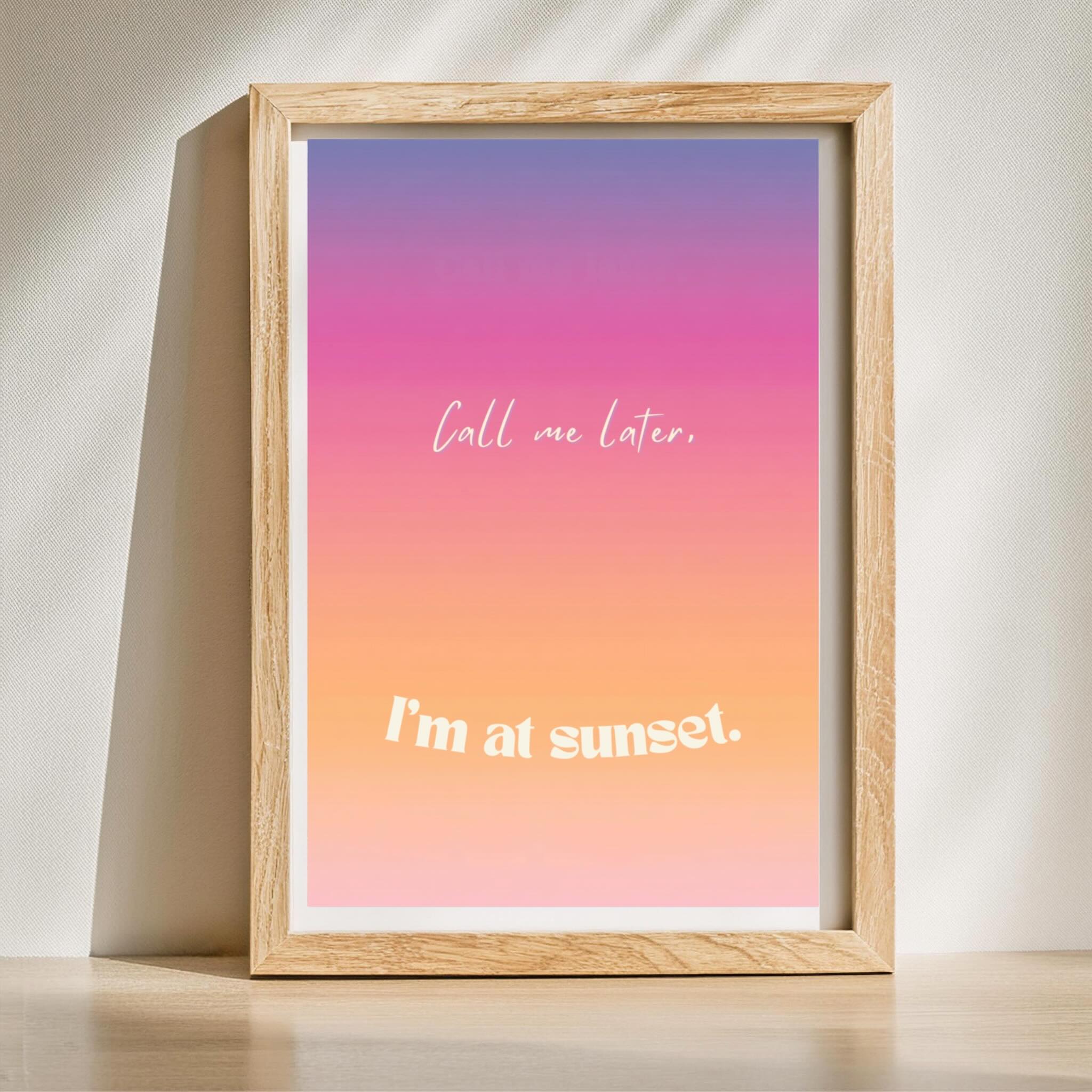 Framed print with gradient background and text 'Call me later. I'm at sunset.' on a light surface.