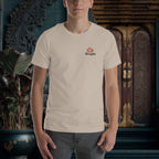 Person wearing a beige t-shirt with a logo in front of decorative wall art