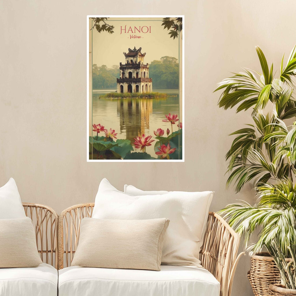 Poster of Hanoi with a pagoda and lotus flowers on a beige wall above a wicker chair.