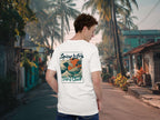 Spicy Lotus Surf Club Sunrise Wave back print T-shirt on a young man standing on a street in Bali