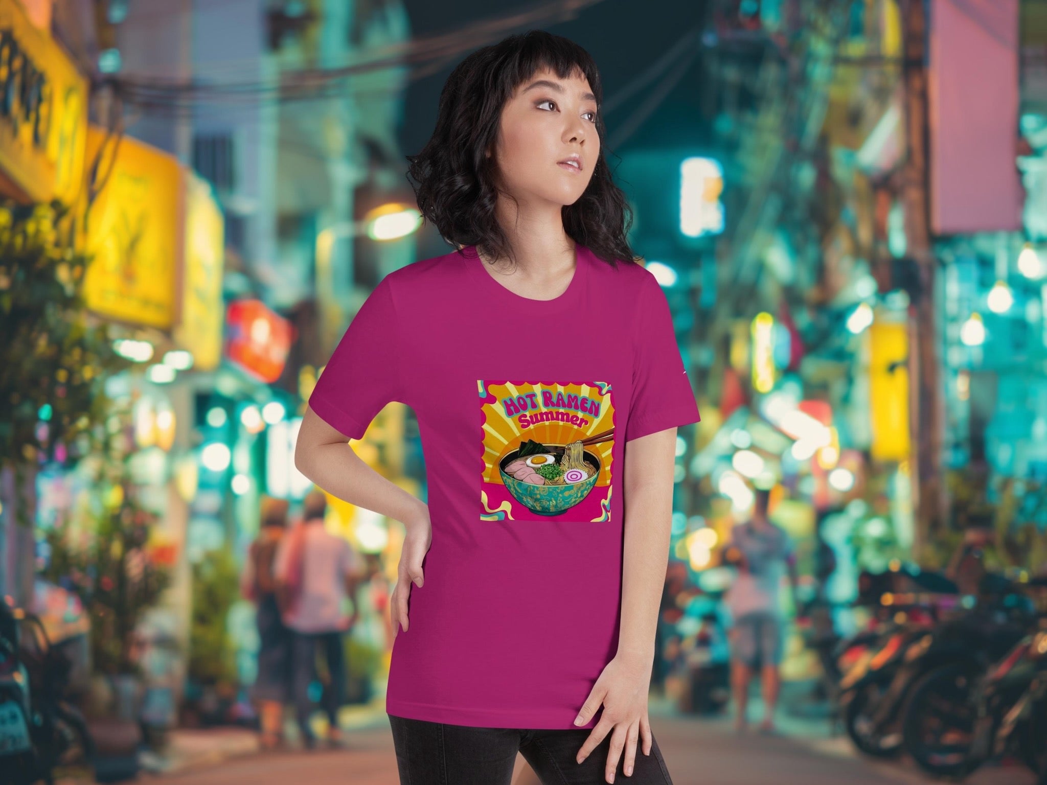 Person wearing a pink t-shirt with a colorful Hot Ramen Summer retro pop art ramen t-shirt in an urban street setting