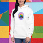 Person wearing a white hoodie with a colorful design of two cute mochis against a multicolored geometric background