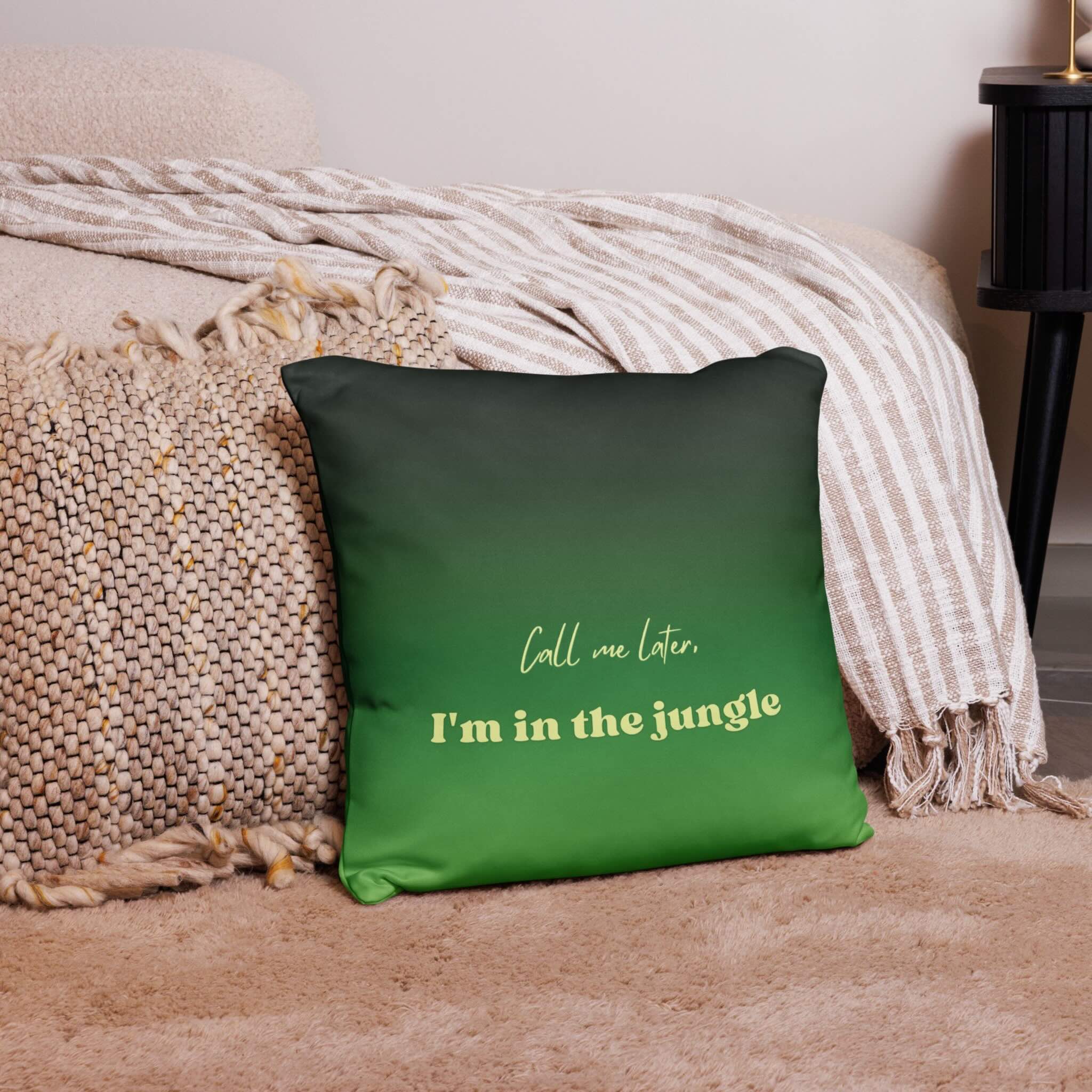 Green pillow with text on a bed with beige bedding
