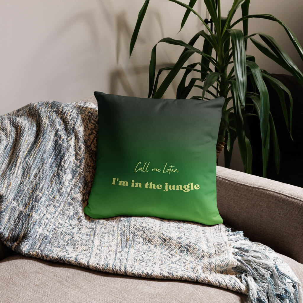 Green pillow with text on a couch next to a plant