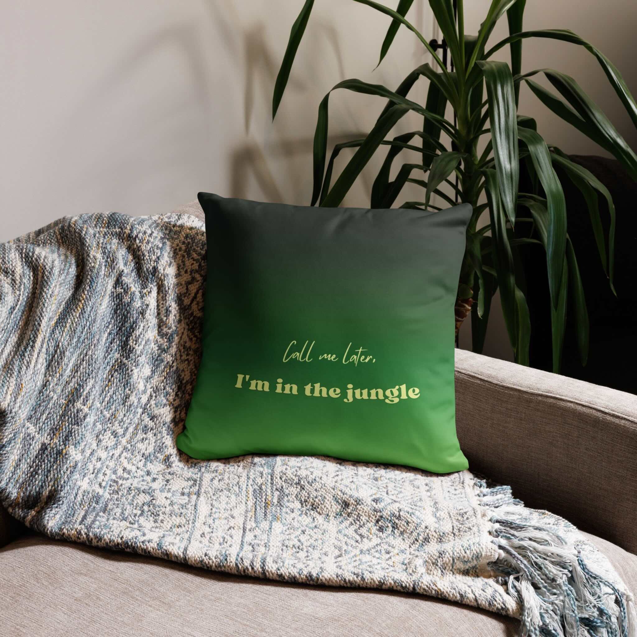Green pillow with text on a couch next to a plant