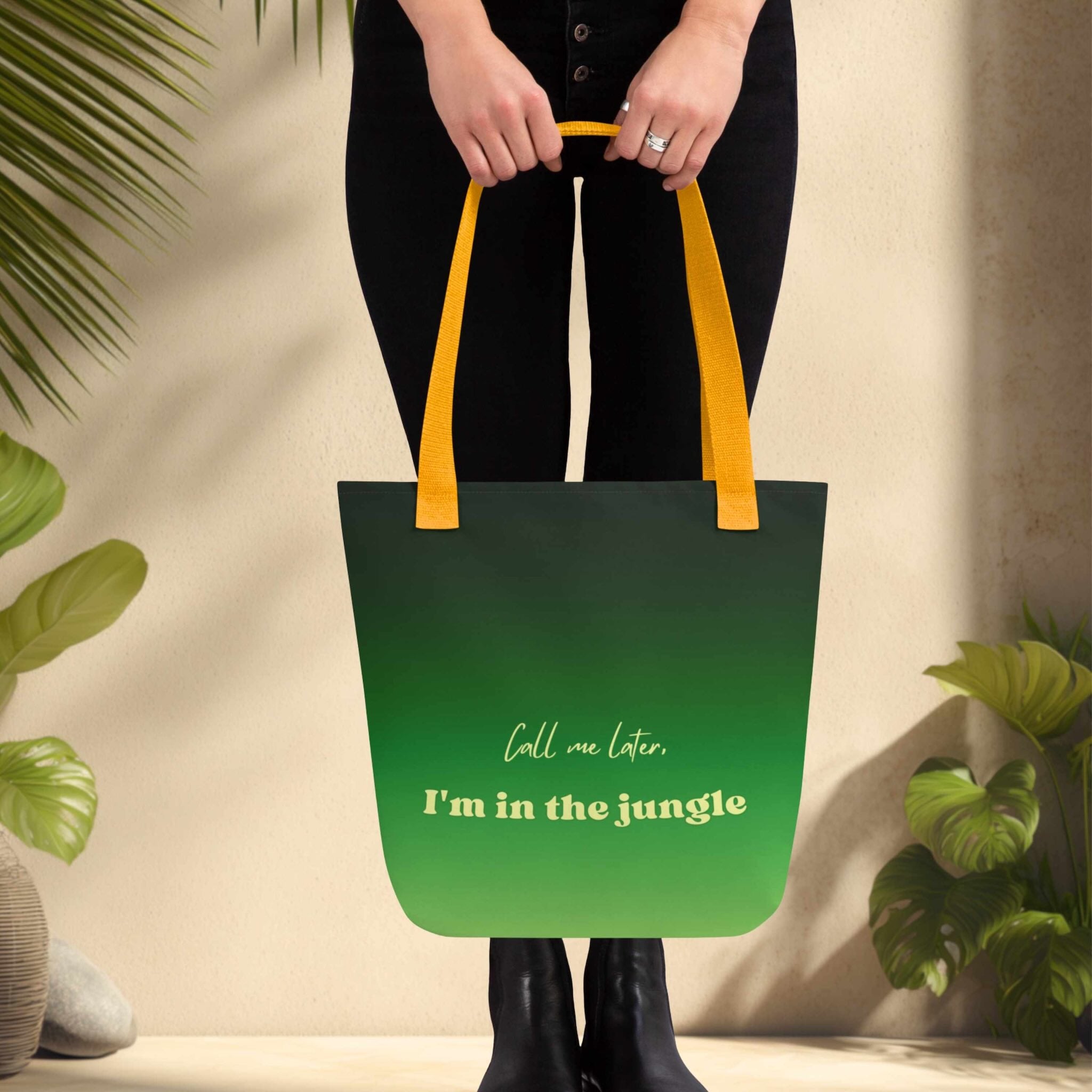Woman holding a green tote bag with text, surrounded by plants.