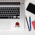 Laptop with a Tiger sticker, phone, and writing utensils on a white surface