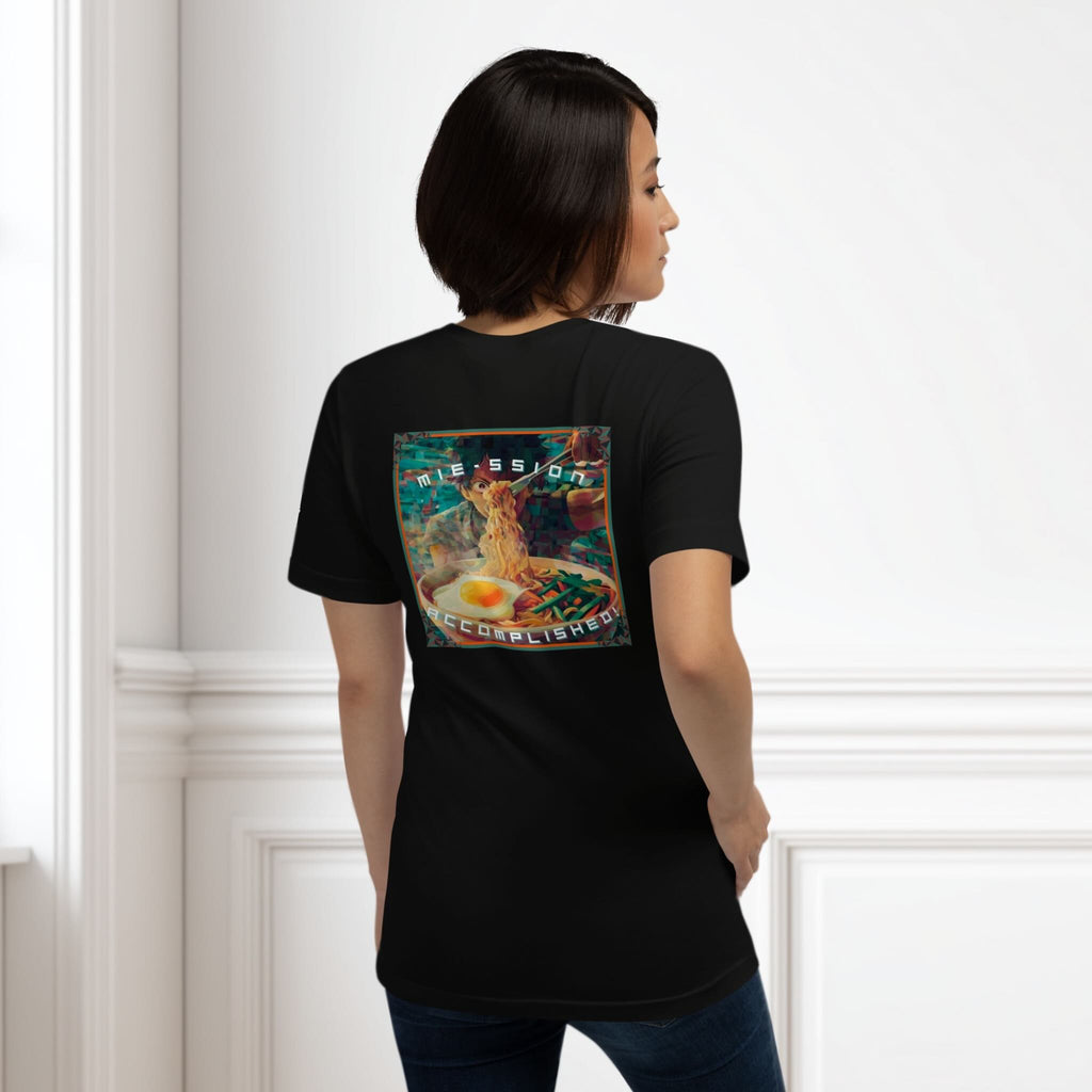Person wearing a black t-shirt with a colorful graphic of a mie noodle dish on the back, standing against a white wall.