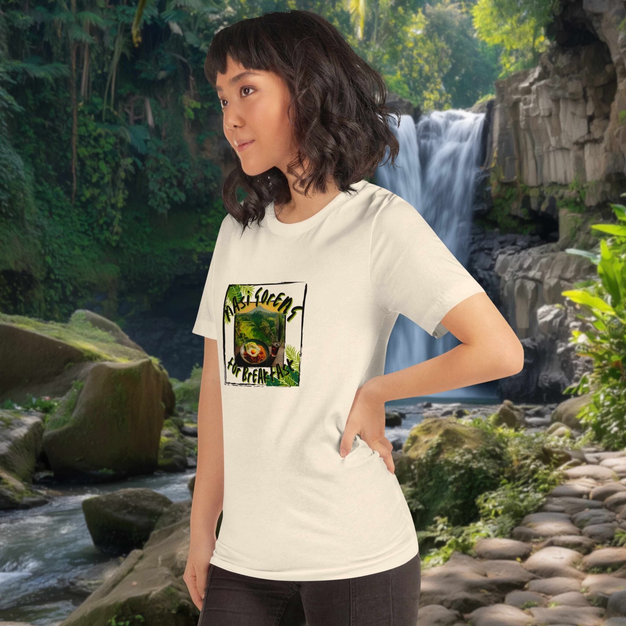 Person wearing a white t-shirt with a nasi goreng design in front of a waterfall