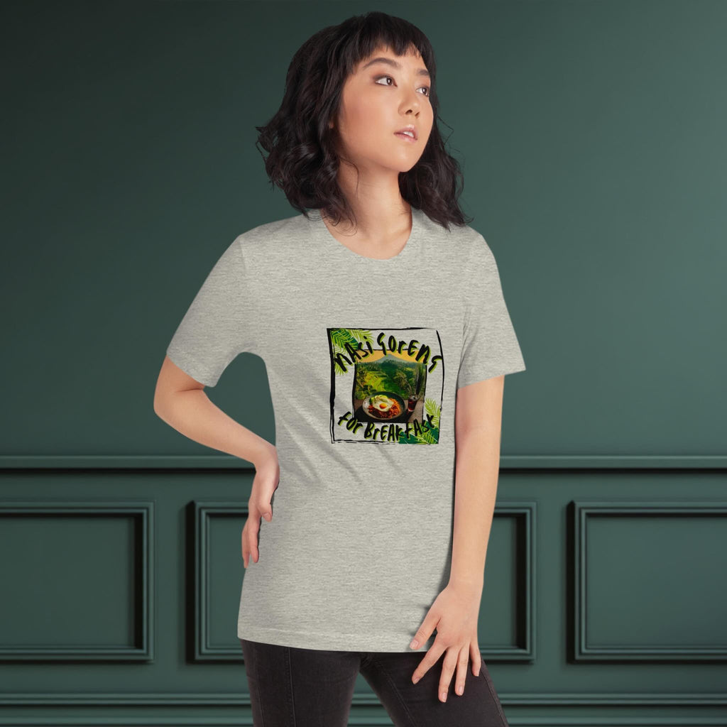 Person wearing a gray t-shirt with a graphic design on a dark green background