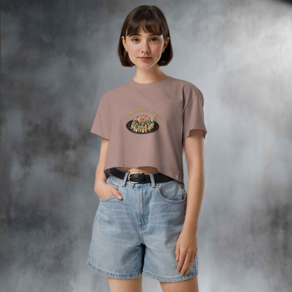 Person wearing a beige t-shirt with a graphic design  of japanese pancake and denim shorts in a studio setting