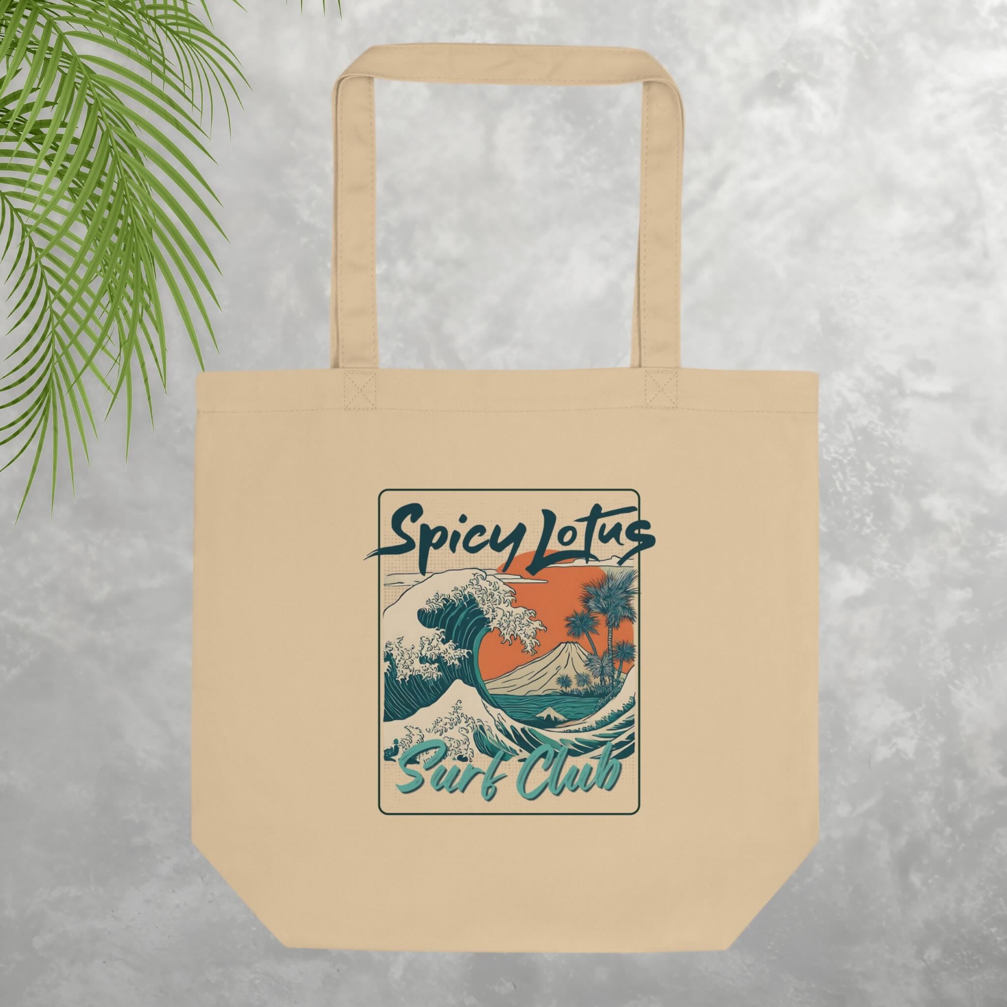 Beige tote bag with 'Spicy Lotus Surf Club' design on a textured gray background
