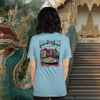 Person wearing a light blue t-shirt with a colorful Pad Thai graphic design in front of a Thai temple with a dragon statue.