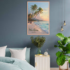 Framed artwork of a tropical beach scene on a blue wall above a bed.