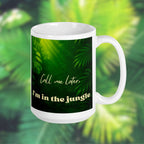 White 15 oz mug with green leafy pattern and text 'Call me later, I'm in the jungle' on a blurred green foliage background.