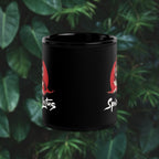 Black mug with red tiger design and text on a green leafy background