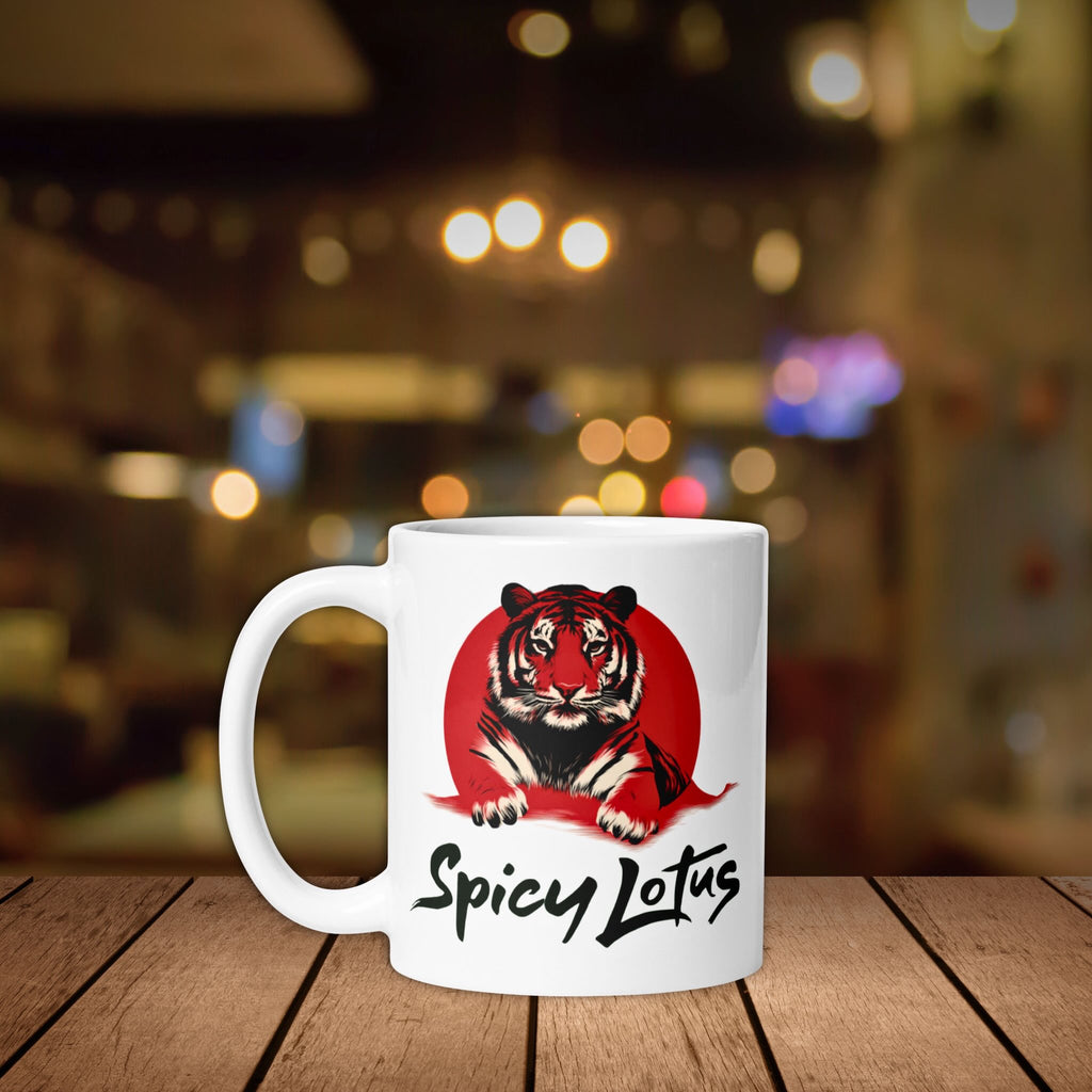 White mug with a tiger design and 'Spicy Lotus' text on a wooden surface with a blurred background.