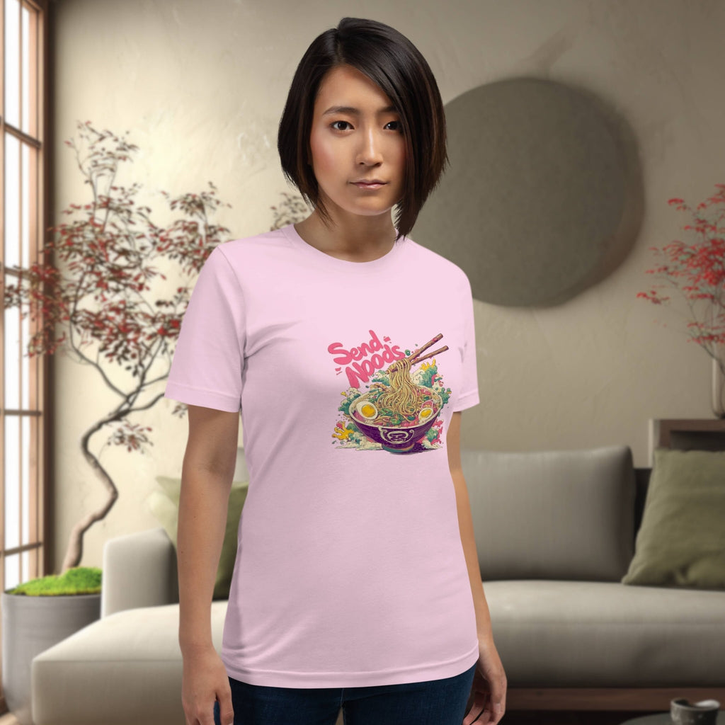 Person wearing a pink t-shirt with a colorful graphic design of japanese ramen 'send noods' in a living room setting