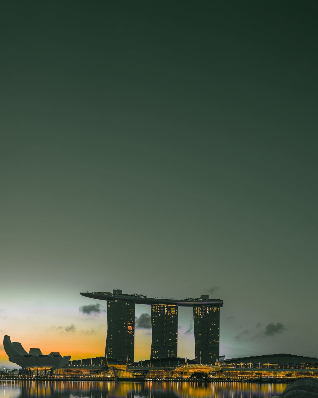Singapore Marina Bay silhouette against a colorful green sunset sky